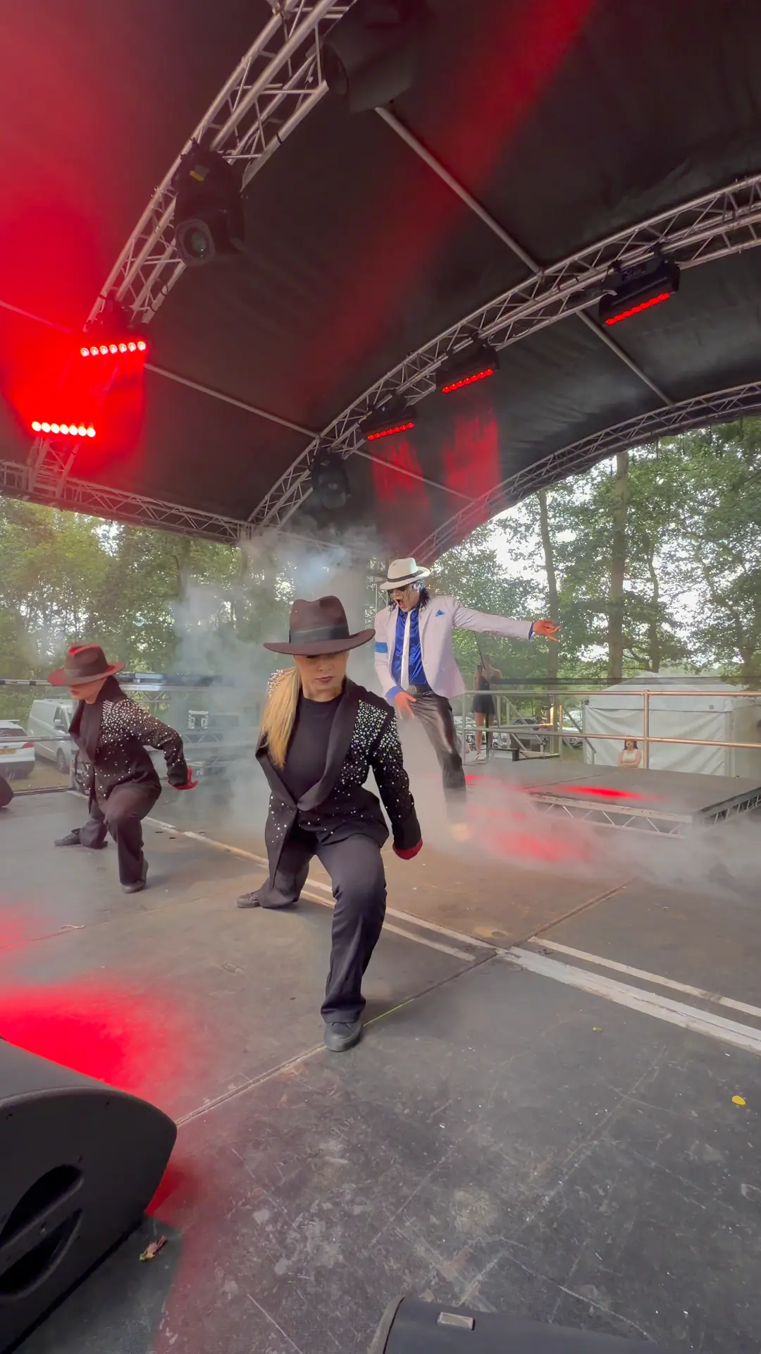 Performers dancing on stage at a Michael Jackson tribute show, filmed vertically